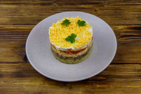 Traditional russian salad Mimosa on wooden tableの写真素材