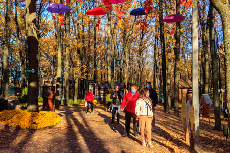 Kharkiv, Ukraine - October 22, 2021: People walking on a pathway in Feldman Ecopark in Kharkiv,...
