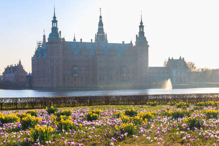 View of Frederiksborg castle in Hillerod, Denmark. Beautiful lake and garden with crocuses and daffodils on a foregroundのeditorial素材