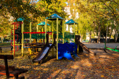 Colorful playground equipment for children in public park at autumnの写真素材