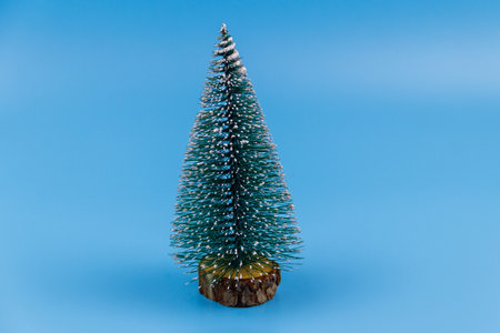 Christmas tree on a pastel blue background. Christmas or New Year concept. Minimal design