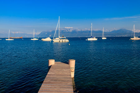 Wooden pier overlooking the Alps and Lake Geneva in Switzerlandの写真素材