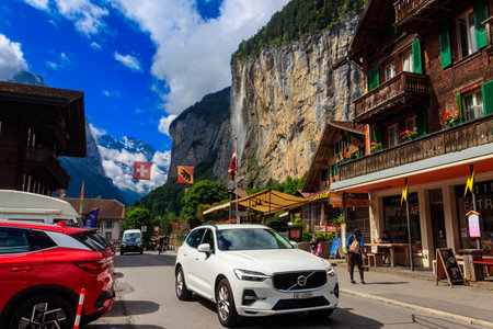 Lauterbrunnen, Switzerland - July 2, 2023: View of traditional swiss houses and Staubbach waterfall in famous Lauterbrunnen village, Bernese Oberland, Switzerlandのeditorial素材