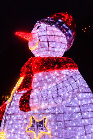 Illuminated snowman at night. Decoration for Christmas and New Years holidays in a city parkの写真素材