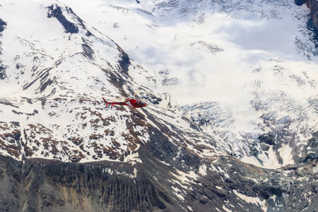 Helicopter flying over the snowy Swiss Alps in Switzerlandの写真素材