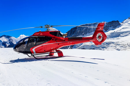 Red helicopter landed at Jungfrau mountain in Bernese Oberland, Switzerlandの写真素材