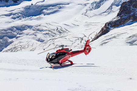 Red helicopter landed at Jungfrau mountain in Bernese Oberland, Switzerlandの写真素材