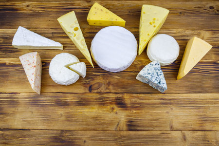 Set of various types of cheese on wooden table. Top view