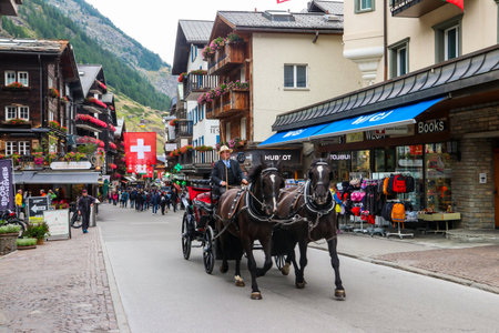 Zermatt, Switzerland - August 31, 2023: Traditional retro horse-drawn carriages carrying tourists in Zermatt, Switzerlandのeditorial素材