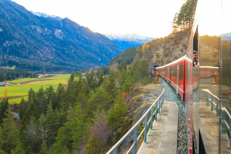 Red passenger train on Rhaetian railway in Canton Graubunden, Switzerland at autumnのeditorial素材