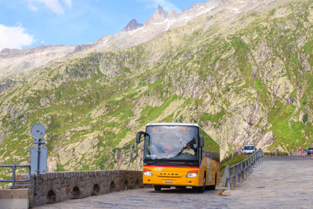 Grimsel pass, Switzerland - August 15, 2024: Typical swiss yellow post bus Postauto at Grimsel pass, Switzerlandのeditorial素材