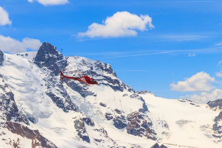 Helicopter flying over the snowy Swiss Alps in Switzerlandの写真素材
