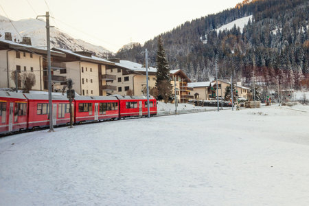 Red passenger train on Rhaetian railway in Canton Graubunden, Switzerland at winterの写真素材