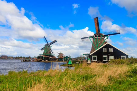 Traditional dutch windmills at the Zaan river in Zaanse Schans village, Netherlandsの写真素材