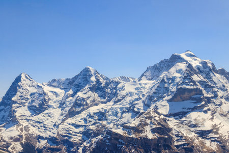 View of three famous Swiss mountain peaks Eiger, Monch and Jungfrau in the Bernese Oberland in Switzerlandの写真素材