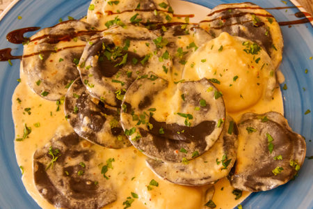 Black ravioli with lobster filling in creamy sauce. Top viewの写真素材