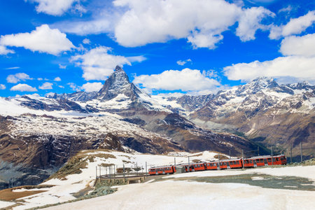 Scenic view on snowy Matterhorn mountain peak in the Swiss Alps with cogwheel train of Gornergrat railway close to Zermatt, Switzerlandの写真素材