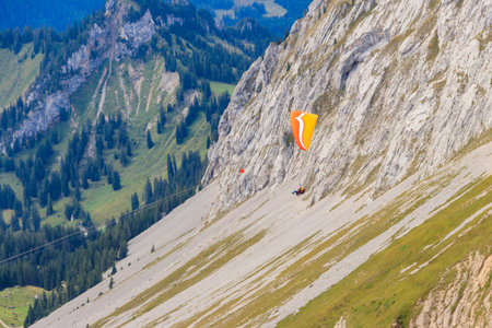 Paragliders flying from Pilatus mountain in Swiss Alps, Switzerland. Concept of active lifestyle and extreme sport adventureの写真素材