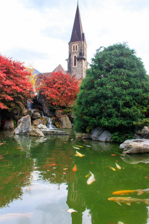 Catholic Church of St. Joseph and artificial pond with fish at autumn in Interlaken, Switzerlandの写真素材