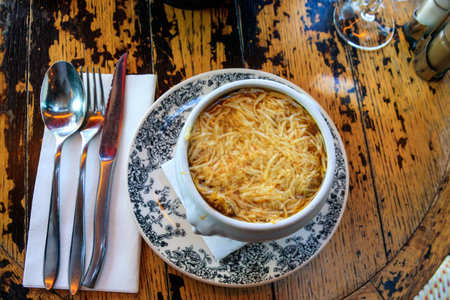 Classic french onion soup baked with cheese and croutons on a table in restaurant