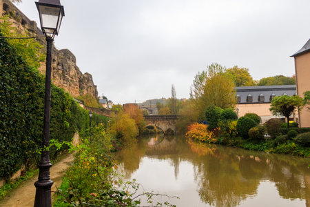 Small stone arched bridge across the Alzette River in the Grund, lower part of Luxembourg city, Luxembourg. Scenic autumn landscapeの写真素材