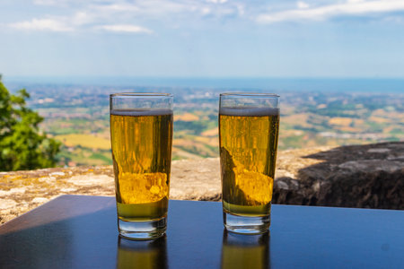 Two glasses of beer on a table with a view of San Marino