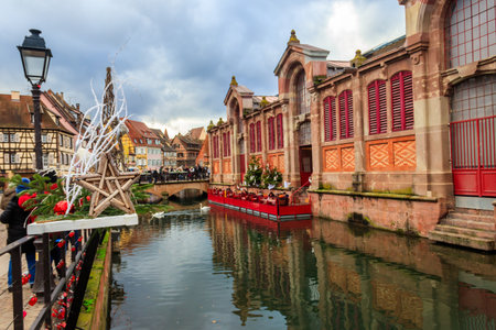 Colmar, France - December 6, 2023: View of the Market Hall on the Lauch River during Christmas time in Colmar, Franceの写真素材