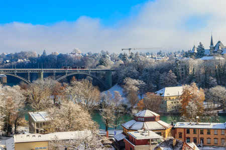 View to the Kirchenfeld bridge with running red tram on winter snowy day in Bern, Switzerlandの写真素材