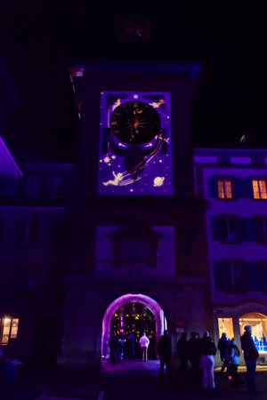 Murten, Switzerland - January 18, 2023: Brentor or Bern Gate with clock illuminated on the light festival in Murten, Switzerlandのeditorial素材