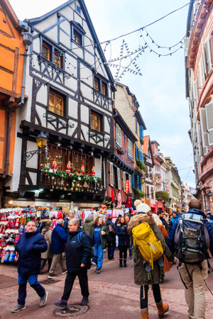 Colmar, France - December 6, 2023: People walking in old town of Colmar with traditional colorful half-timbered houses, decorated for Christmas time in Alsace, Franceのeditorial素材