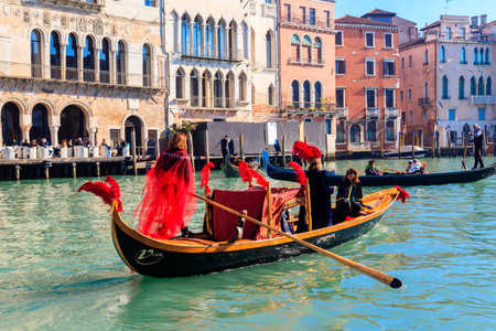 Venice, Italy - February 12, 2023: People in carnival costumes in gondola sailing at Grand Canal in Venice, Italyのeditorial素材
