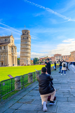 Pisa, Italy - November 8, 2022: Tourists taking photos with Leaning tower of Pisa at the Piazza dei Miracoli or the Square of Miracles in Pisa, Italyのeditorial素材
