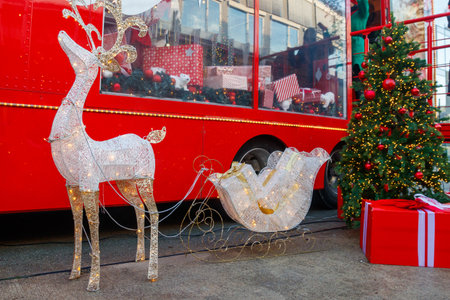Illuminated Christmas deer with sleigh. Decoration for Christmas and New Years holidays in a city parkの写真素材