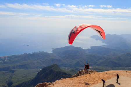 Antalya Province, Turkey - October 23, 2020: Paragliders flying from a top of Tahtali mountain near Kemer, Antalya Province in Turkey. Concept of active lifestyle and extreme sport adventureのeditorial素材
