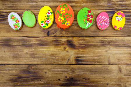 Egg shaped easter gingerbread cookies on wooden table. Top view, copy space. Sweets for celebrate...
