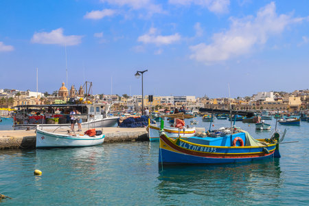 Marsaxlokk, Malta - May 18, 2025: Traditional colorful fishing boats luzzu in the harbor of Mediterranean fishing village Marsaxlokk, Maltaのeditorial素材