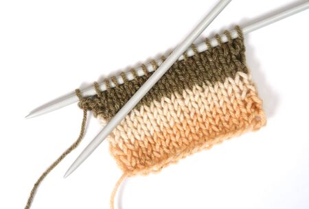 Knitting a color fluffy wooll, with knitting needles. Isolated on white 