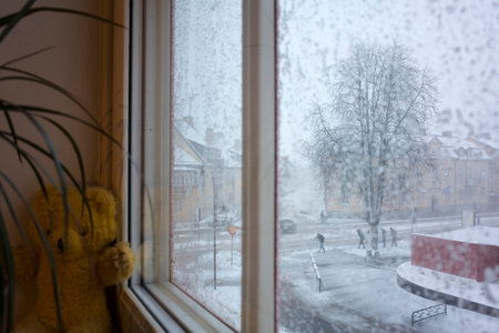 Snow storm in Sweden, Strong wind Vasteras city street view through snow covered window, Winter nasty weather in Scandinaviaの写真素材