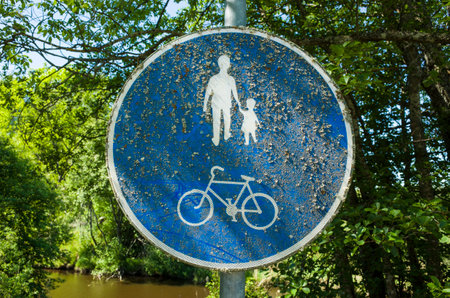 Mossy road sign pedestrian walkway and cycling path. Road sign in Sweden in green summer outdoorsの写真素材