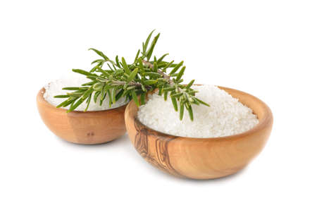 	Salt in a wooden bowl and rosemary on a white backgroundの写真素材