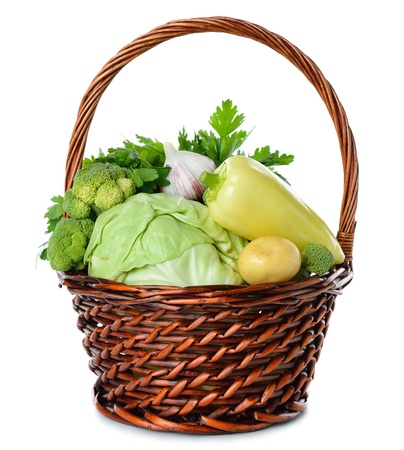 Various vegetables in a brown basket isolated on white backgroundの写真素材