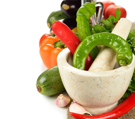 mortar and fresh vegetables on a white backgroundの写真素材