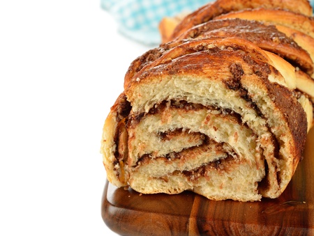 Twisted sweet bread with chocolate and nuts on a white background