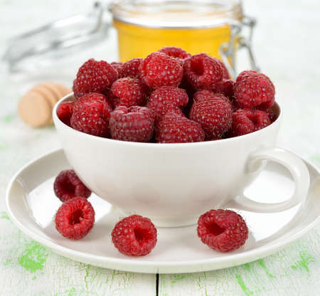 fresh raspberries in white cup close up