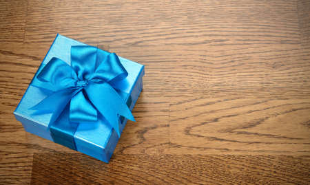Box decorated with ribbon on brown backgroundの写真素材