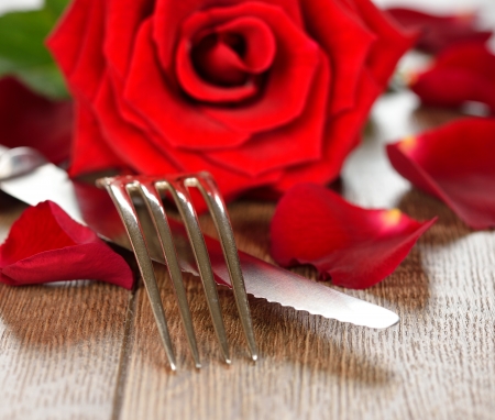 Cutlery and rose on a brown tableの写真素材