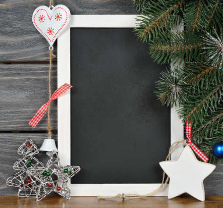 Writing board and Christmas decorations on a gray background