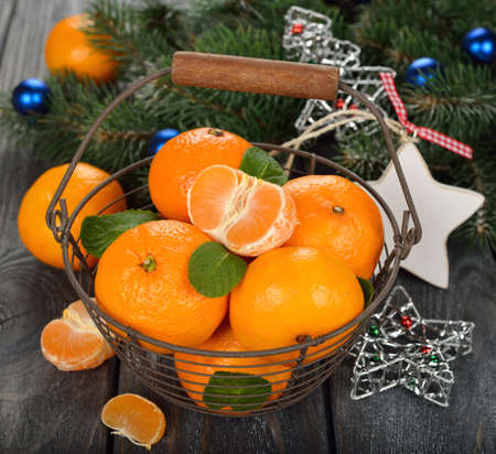 Mandarins in the basket and Christmas decorations on a gray backgroundの写真素材