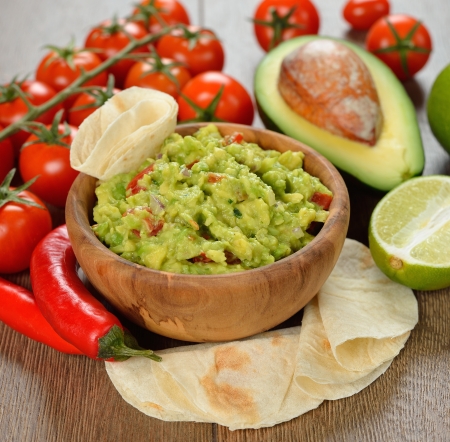 Guakamole and fresh vegetables on brown の写真素材