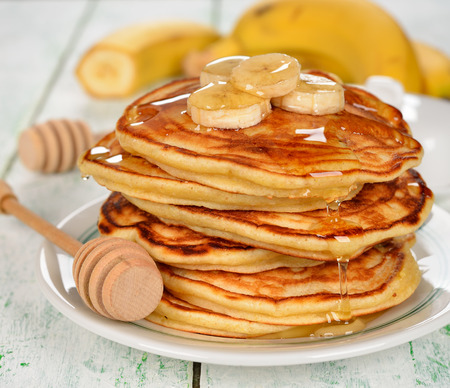 Pancakes with banana and honey on a white backgroundの写真素材